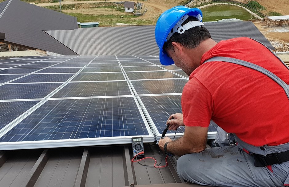 Solar panel installer on a roof installing a solar panel.