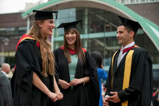 University students on gowns and mortar boards on graduation day